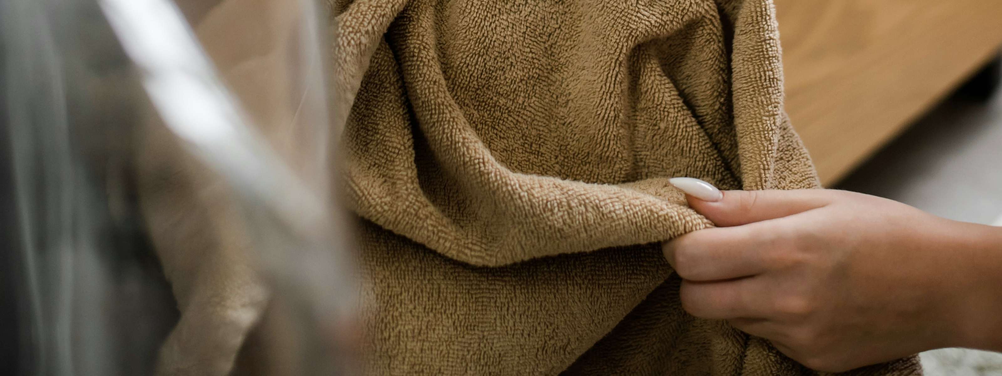 Nahaufnahme eines weichen Handtuchs in neutralen Farben, Symbol für Pflege und Langlebigkeit von Textilien