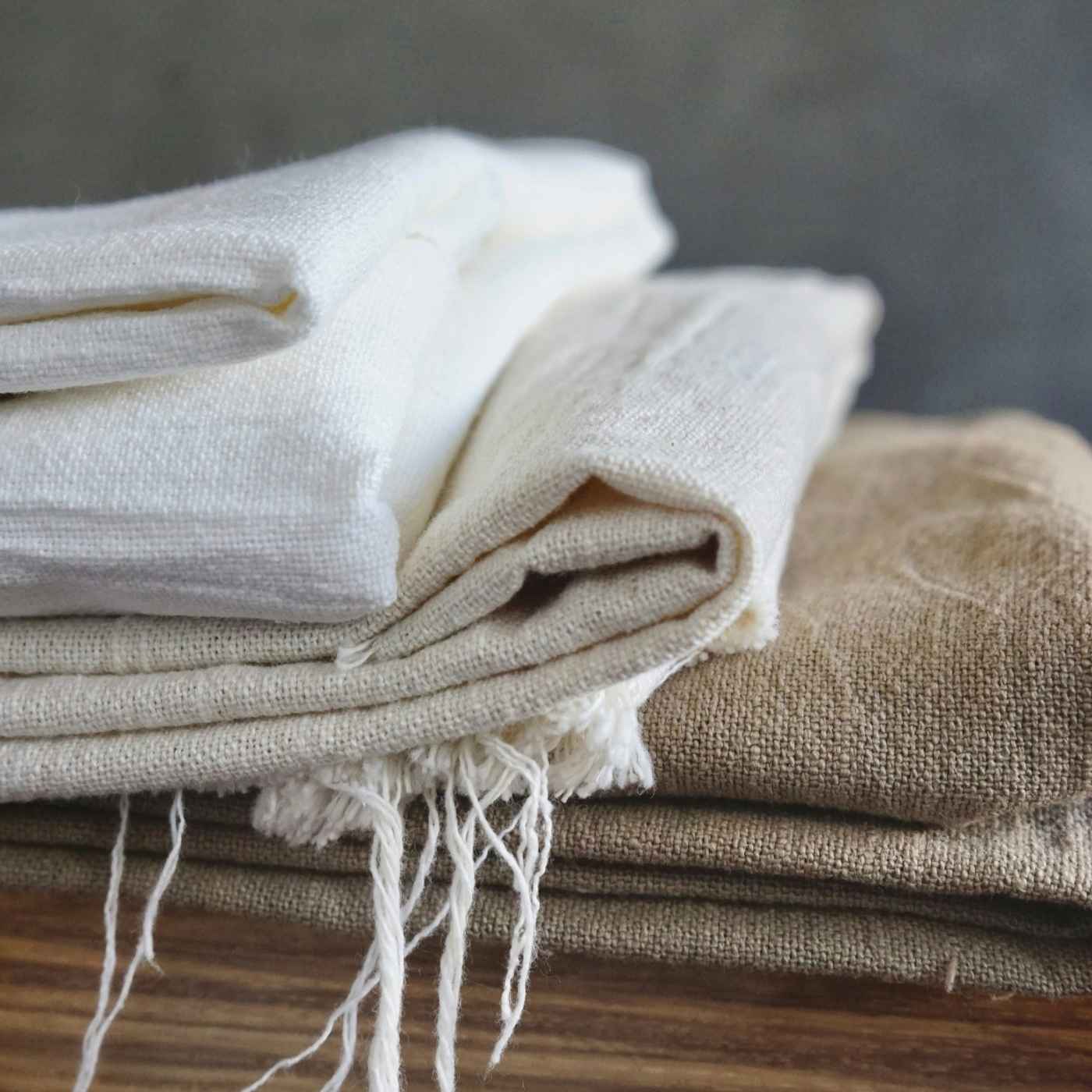 Nahaufnahme eines gestapelten Mischgewebes in neutralen Farben wie Weiß und Beige, mit sichtbarer Struktur